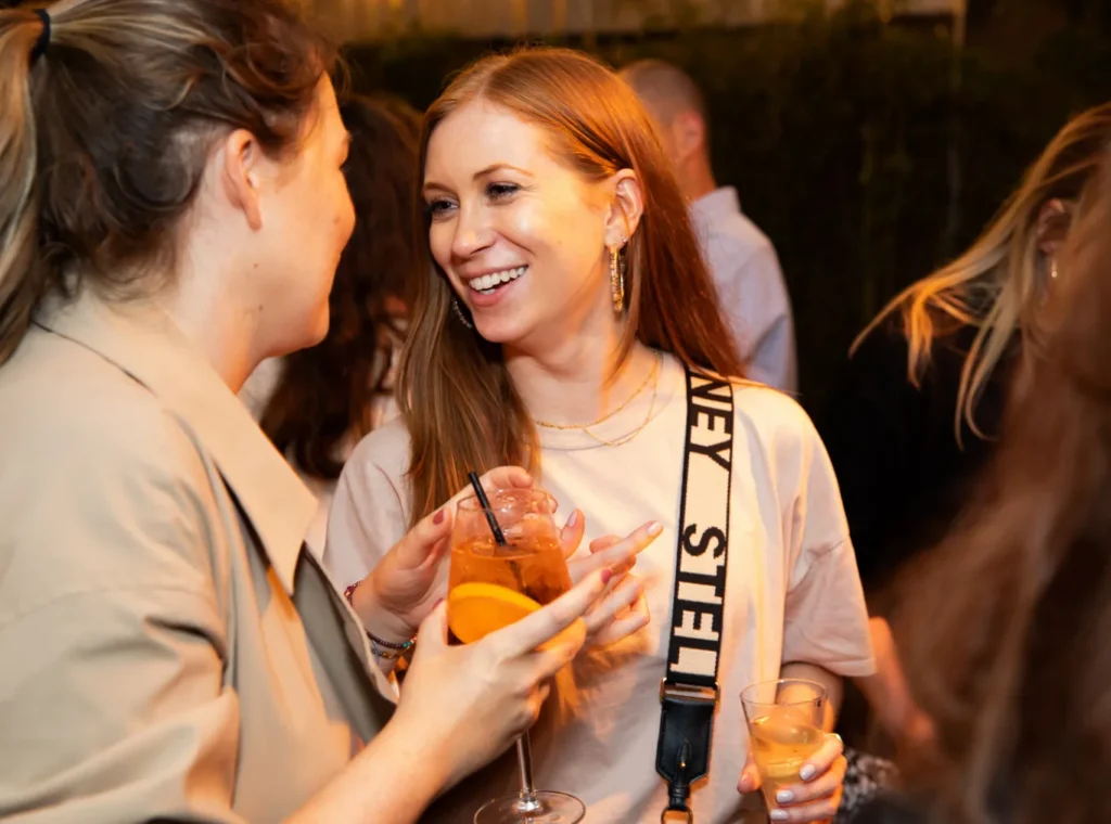 Two girls drinking cocktails at a party