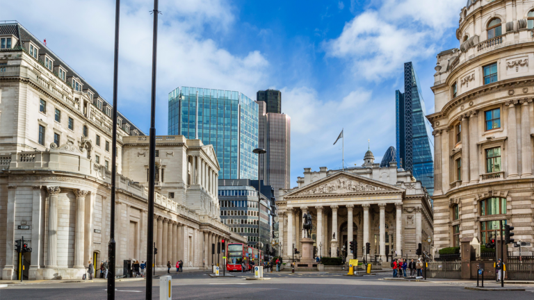 A wide-angle view of the Bank of England and the Royal Exchange in London, landmarks central to the UK governments financial services sector, surrounded by historic and modern buildings under a partly cloudy sky.