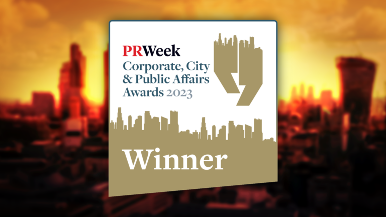 An award plaque with the text: PRWeek Corporate, City & Public Affairs Awards 2023 Winner, featuring a city skyline graphic and a blurred cityscape background, celebrating MHP Group as Team and Leader of the Year at the PR Week Awards.