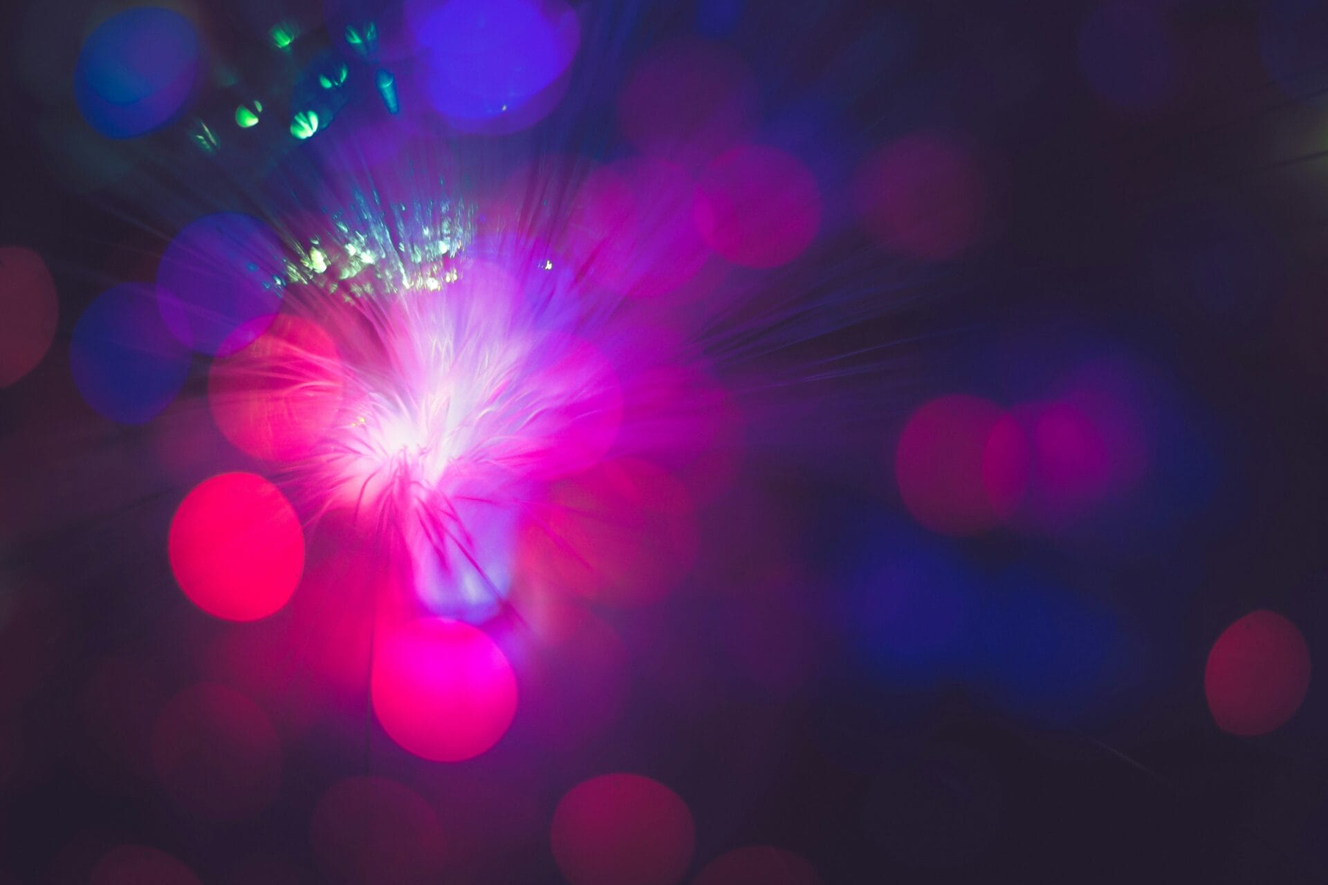 Abstract image with vibrant pink, purple, and blue bokeh lights radiating outward, creating a dreamy and colorful effect against a dark background—perfect for a technology-themed year in review.